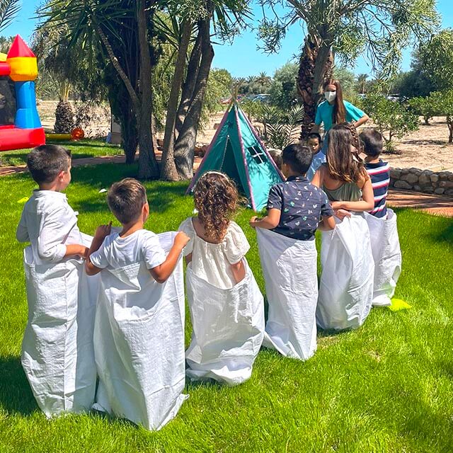 Juegos tradicionales como carrera de sacos en una animación infantil al aire libre
